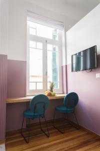 Neratzia Rooms في أثينا: غرفة بها كرسيين وطاولة مع نافذة
