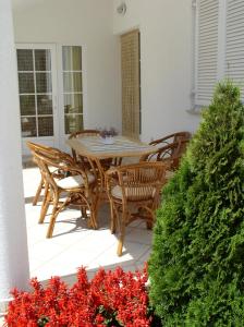 Una mesa y sillas en un patio con flores rojas. en Apartments Paloma Blanca, en Medulin
