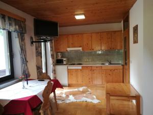 una cocina con mesa y una cocina con armarios de madera. en Turisticna Kmetija Psnak, en Mojstrana