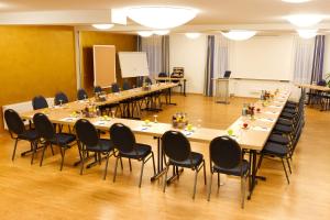 a conference room with long tables and chairs at BusinessHotel Schramberg in Schramberg