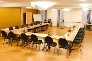 einen Konferenzraum mit langen Tischen und Stühlen in der Unterkunft BusinessHotel Schramberg in Schramberg