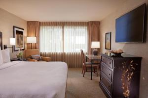 um quarto de hotel com uma cama, uma secretária e uma televisão em Eastgate Hotel - BW Signature Collection em Bellevue