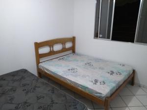 a small bedroom with a bed and a window at Apartamento Praia da Costa in Vila Velha