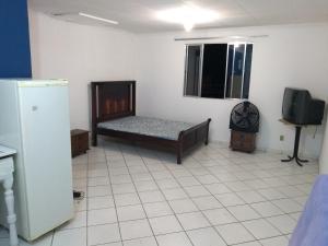 a room with a bed and a tv in it at Apartamento Praia da Costa in Vila Velha