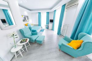 فندق ريلاكس كمفورت سويتس في بوخارست: غرفة معيشة مع كراسي زرقاء وطاولة