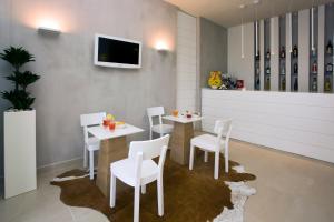 a dining room with white tables and white chairs at Residence Belmare in Rimini