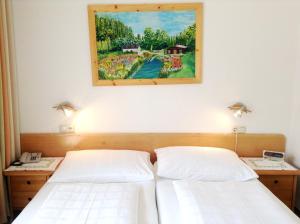 2 Betten in einem Zimmer mit Wandgemälde in der Unterkunft Parkpension Billroth in Bad Hall