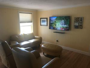 un soggiorno con divano e TV a parete di 1711 Manatee Drive (Beautiful Lake House) a Sebring
