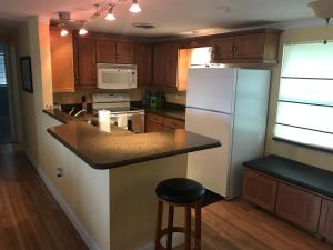 una cucina con frigorifero e bancone con sgabello di 1711 Manatee Drive (Beautiful Lake House) a Sebring