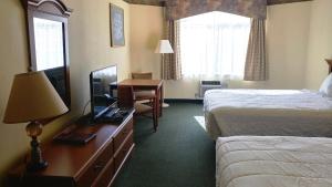 Postel nebo postele na pokoji v ubytování Palace Inn & Suites