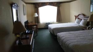 Postel nebo postele na pokoji v ubytování Palace Inn & Suites