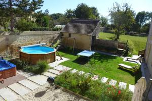 a small backyard with a pool and a house at Le Petit Fort in Bény-sur-Mer