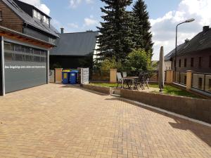 un patio de ladrillo con una mesa y un edificio en Lang´s Ferienwohnungen, en Kurort Oberwiesenthal