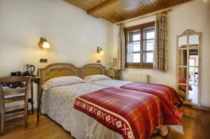 a bedroom with a bed and a desk and a window at San Marsial Benasque Apartamentos y Hotel in Benasque