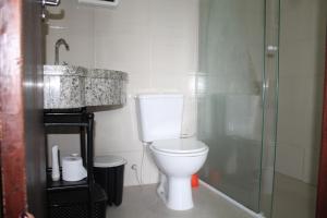 Un baño con inodoro, ducha y lavabo. en Residencial Hannah - Casa 6 - Porto Belo SC - Bairro Perequê, en Porto Belo