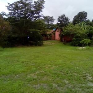 a yard with a house in the background at Pousada Chalés do Lago in Cavalcante