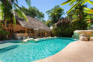 a swimming pool in front of a house with a resort at Bungalows Calalú in Puerto Viejo