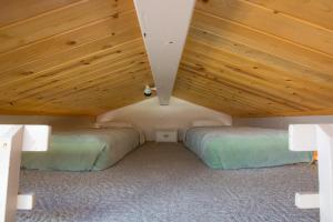 2 łóżka w pokoju z drewnianym sufitem w obiekcie Brettelberg Slopeside Condos E9 w mieście Carbondale