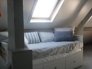 una cama con almohadas en un ático en Aan de Vecht, en Nederhorst den Berg