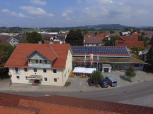 Gasthof Hirsch Betzigau في Betzigau: مبنى بسقف احمر مع موقف للسيارة