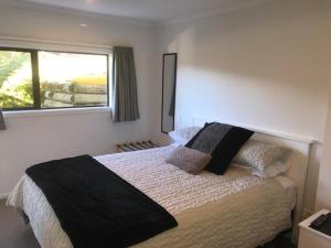 a bedroom with a large bed and a window at Abel Tasman Kaiteriteri B & B in Kaiteriteri