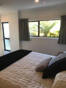 una camera da letto con un letto e due finestre di Abel Tasman Kaiteriteri B & B a Kaiteriteri