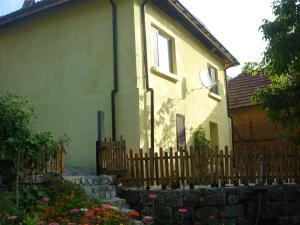 a wooden fence in front of a house at Guest House „Ivanovata house” in Yanʼovets