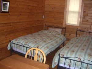 a bedroom with two beds in a log cabin at Lassy Condominium in Nishiharamura