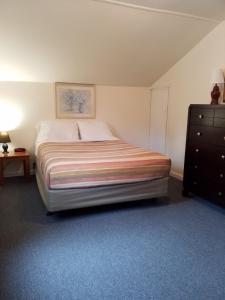 sypialnia z dużym łóżkiem i komodą w obiekcie Bayside Inn & Marina w mieście Cooperstown
