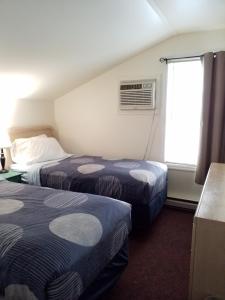 um quarto de hotel com duas camas e uma janela em Bayside Inn & Marina em Cooperstown