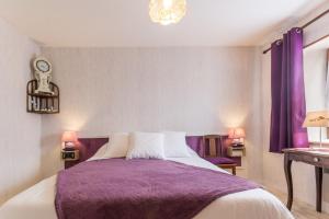 a bedroom with a bed with a purple blanket at Le Gîte du Lavoir in Marzy