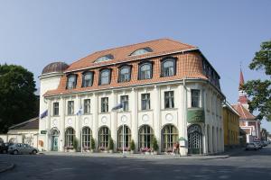 a large white building with a red roof at Hotel Victoria in Pärnu