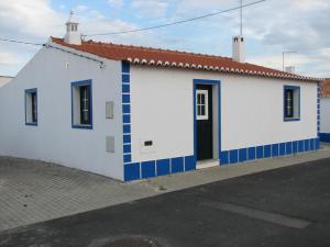 un edificio blanco y azul con techo rojo en Casa da Avó Mina, en Mértola