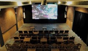 an auditorium with chairs and a large screen at Omah Sinten Heritage Hotel & Resto in Solo