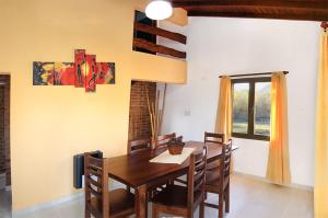 a dining room with a wooden table and chairs at CABAÑAS AGUARI in Santa Rosa de Calamuchita +7 photos