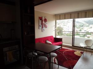 sala de estar con sofá rojo y ventana grande en Departamento En Viña Del Mar, en Viña del Mar