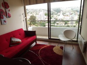 a living room with a red couch and a large window at Departamento En Viña Del Mar in Viña del Mar