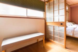 een kleine kamer met een bank en een bed bij Tino Kawara in Osaka