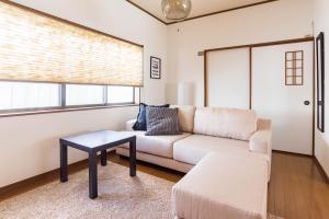 een woonkamer met een bank en een tafel bij Tino Kawara in Osaka +35 foto's