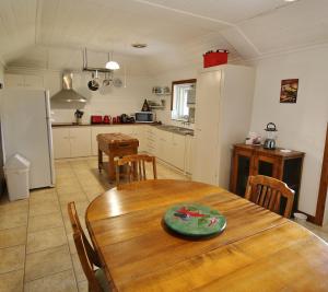 a kitchen and dining room with a wooden table at Stonewall Cottage in Moonta