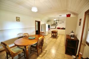 a kitchen and dining room with a wooden table and chairs at Stonewall Cottage in Moonta +49 photos