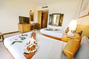 a hotel room with two beds and a desk at Supalai Scenic Bay Resort And Spa, SHA Extra Plus in Por Bay