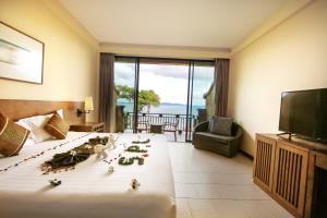 a hotel room with a bed with flowers on it at Supalai Scenic Bay Resort And Spa, SHA Extra Plus in Por Bay