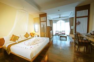 a hotel room with a large bed and a desk at Supalai Scenic Bay Resort And Spa, SHA Extra Plus in Por Bay