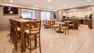 une salle à manger et une cuisine avec des tables et des chaises dans l'établissement Best Western Hotel Brossard, à Brossard