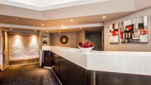 a kitchen with a counter with a bowl of apples on it at Best Western Hotel Brossard in Brossard
