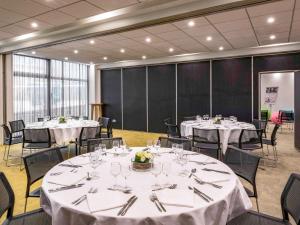 a conference room with tables and chairs with white tablecloths at Mercure Le Havre Centre Bassin Du Commerce in Le Havre