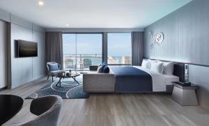 a bedroom with a large bed and a living room at Grande Centre Point Pattaya in Pattaya