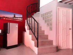 a staircase in a room with a red wall and a refrigerator at Red Samed Party House in Ko Samed