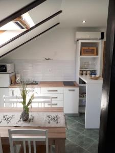 a kitchen with white cabinets and a table and chairs at Guest House Klaudija in Trogir